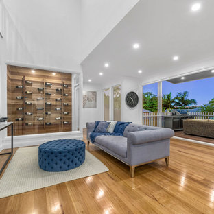This is an example of a mid-sized transitional family room in Brisbane with a home bar, white walls, medium hardwood floors and brown floor.