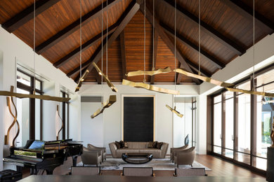 Huge tuscan formal and open concept medium tone wood floor and vaulted ceiling living room photo with white walls