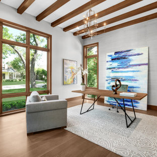 This is an example of a mediterranean study in Dallas with grey walls, medium hardwood flooring, no fireplace and a freestanding desk.