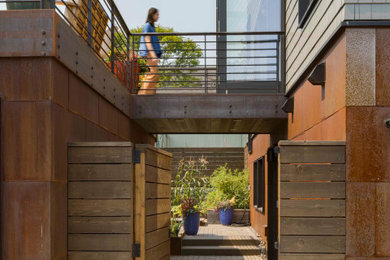 Example of a backyard second story metal railing deck design in Seattle