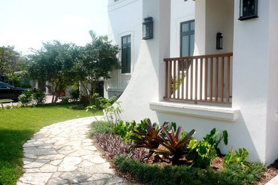 Inspiration for a mid-sized mediterranean partial sun front yard stone formal garden in Miami for summer.