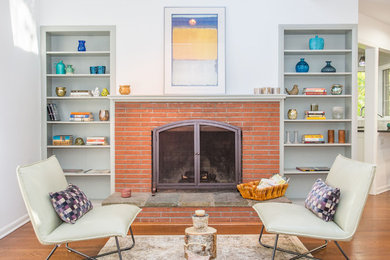 Example of a transitional formal medium tone wood floor living room design in New York with blue walls, a standard fireplace, a brick fireplace and no tv