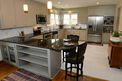 Elegant u-shaped eat-in kitchen photo in Other with an undermount sink, flat-panel cabinets, gray cabinets, granite countertops, gray backsplash and stainless steel appliances