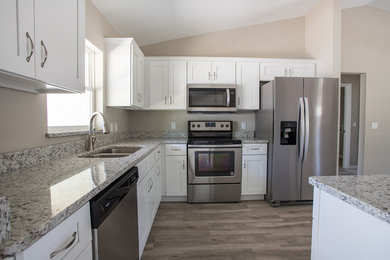 Photo of a transitional eat-in kitchen in Other with an undermount sink, shaker cabinets, white cabinets, granite benchtops, stainless steel appliances, with island and multi-coloured benchtop.