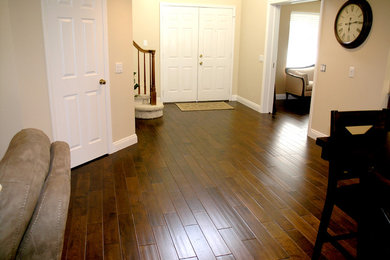 Example of a mid-sized classic medium tone wood floor and brown floor entryway design in Other with beige walls and a white front door
