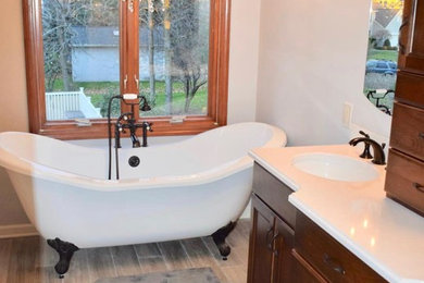 Bathroom - large transitional master white tile and marble tile ceramic tile and gray floor bathroom idea in New York with recessed-panel cabinets, dark wood cabinets, a two-piece toilet, gray walls, an undermount sink, quartzite countertops, a hinged shower door and gray countertops