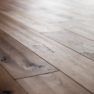 Photo of a large rustic look-out basement in Minneapolis with brown walls and light hardwood flooring.
