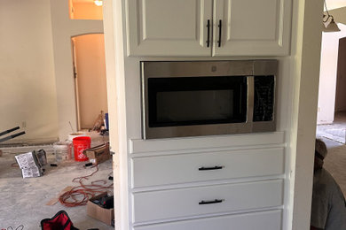 Mid-sized eat-in kitchen photo in Other with raised-panel cabinets, white cabinets and a peninsula