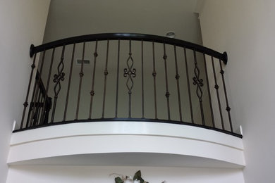 Large tuscan wooden curved staircase photo in Charlotte with painted risers