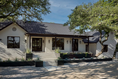 Large contemporary white split-level brick exterior home idea in Austin with a metal roof and a black roof
