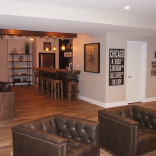 シカゴの大きいラスティックスタイルのおしゃれな地下室 (半地下 (窓あり) 、グレーの壁、セラミックタイルの床、標準型暖炉、木材の暖炉まわり、マルチカラーの床) の写真