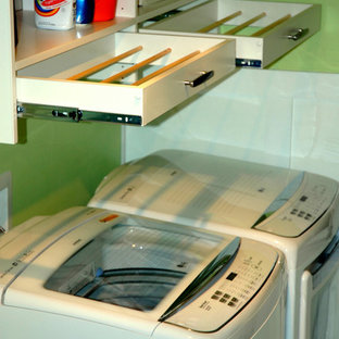 Ejemplo de cuarto de lavado lineal, actual, grande, con armarios con paneles lisos, puertas de armario blancas, paredes verdes, suelo de linóleo y lavadora y secadora juntas