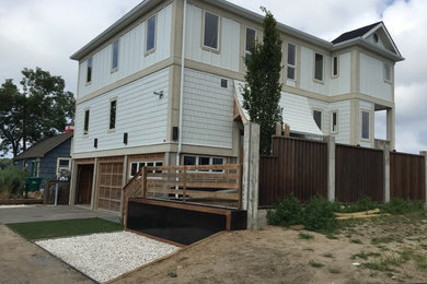 Large beach style white two-story mixed siding exterior home photo in New York with a shingle roof