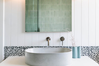 Modernes Badezimmer mit flächenbündigen Schrankfronten, hellbraunen Holzschränken, schwarz-weißen Fliesen, weißer Wandfarbe, Aufsatzwaschbecken, weißer Waschtischplatte und Einzelwaschbecken in Adelaide