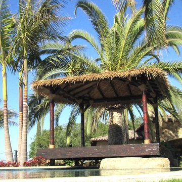 12'x12' Maldives inspired Hut in Synthetic thatch - carved poles in teak stain