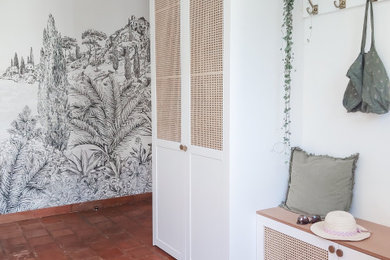 Aménagement d'un hall d'entrée contemporain avec un mur blanc, tomettes au sol, un sol marron et du papier peint.