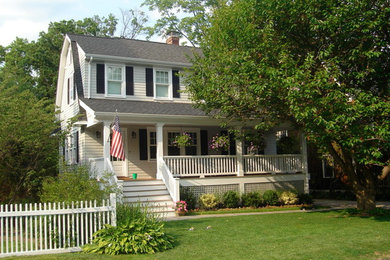 This is an example of a mid-sized traditional two-storey beige house exterior in New York with wood siding, a gambrel roof and a shingle roof.