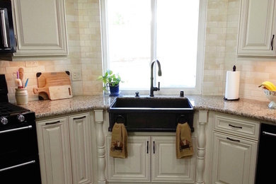 Open concept kitchen - mid-sized traditional u-shaped dark wood floor and brown floor open concept kitchen idea in Los Angeles with a farmhouse sink, raised-panel cabinets, white cabinets, granite countertops, multicolored backsplash, porcelain backsplash, black appliances and a peninsula