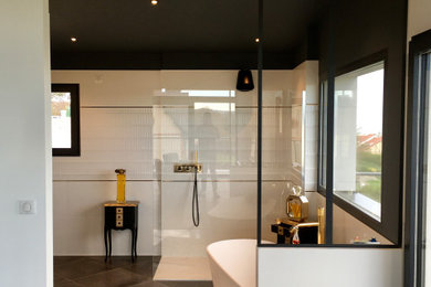 Exemple d'une salle de bain tendance avec une baignoire indépendante, une douche à l'italienne, un carrelage blanc et meuble double vasque.