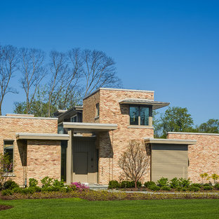 Новые идеи обустройства дома: большой, двухэтажный фасад частного дома розового цвета в стиле модернизм с облицовкой из кирпича и плоской крышей