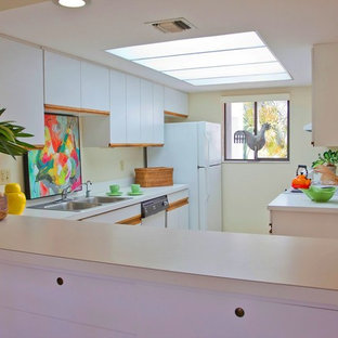 Photo of a small tropical galley kitchen pantry in Miami with flat-panel cabinets and white cabinets.