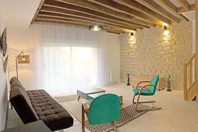 Cette image montre un salon minimaliste de taille moyenne et fermé avec un mur blanc, un sol en calcaire, poutres apparentes, un sol beige et un mur en pierre.