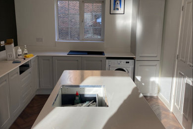 This is an example of a modern kitchen in Kent with engineered stone countertops and white worktops.