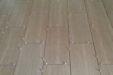 Example of a large classic porcelain tile eat-in kitchen design in New York with raised-panel cabinets and no island