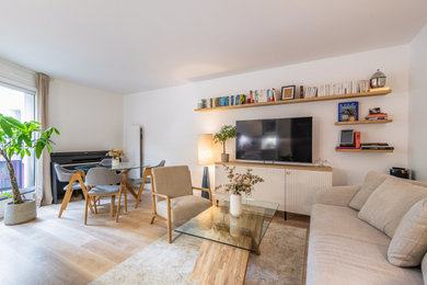 Imagen de salón abierto y blanco y madera tradicional renovado de tamaño medio sin chimenea con paredes blancas, suelo de madera clara, televisor colgado en la pared y suelo beige