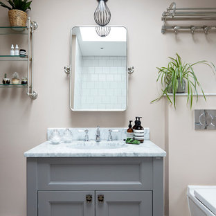 Ispirazione per una piccola stanza da bagno per bambini minimalista con ante lisce, ante grigie, vasca da incasso, vasca/doccia, WC sospeso, piastrelle bianche, piastrelle in ceramica, pareti rosa, pavimento con piastrelle in ceramica, lavabo da incasso, top in marmo, pavimento grigio, porta doccia a battente e top bianco