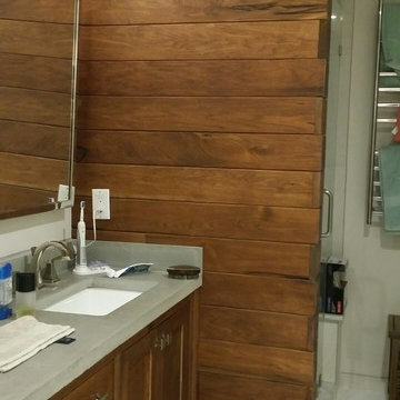 Walnut vanity with concrete top and walnut accent wall