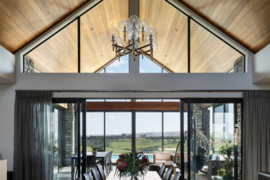 Свежая идея для дизайна: большая гостиная-столовая с белыми стенами, паркетным полом среднего тона, коричневым полом и сводчатым потолком - отличное фото интерьера