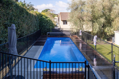 Foto de piscina de tamaño medio rectangular en patio trasero con paisajismo de piscina y entablado