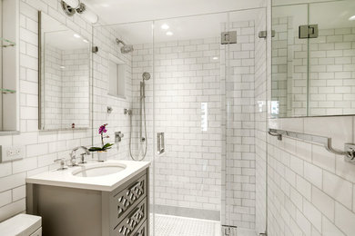 Photo of a mid-sized transitional 3/4 bathroom in New York with brown cabinets, an alcove shower, white tile, subway tile, an undermount sink, engineered quartz benchtops, a hinged shower door and white benchtops.
