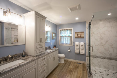 Inspiration for a mid-sized transitional master beige tile and ceramic tile wood-look tile floor, brown floor and double-sink bathroom remodel in Philadelphia with beige cabinets, a two-piece toilet, blue walls, an undermount sink, granite countertops and brown countertops