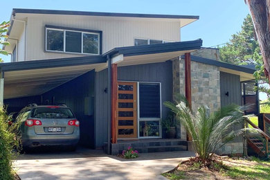 Contemporary two-storey grey house exterior in Canberra - Queanbeyan with concrete fiberboard siding, a flat roof and a metal roof.