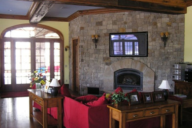 Living room - mid-sized traditional enclosed dark wood floor living room idea in Denver with a wood stove, a brick fireplace and a wall-mounted tv
