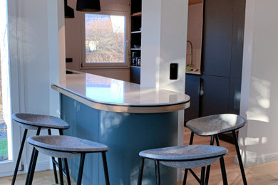 Offene, Zweizeilige, Mittelgroße Moderne Küche mit flächenbündigen Schrankfronten, blauen Schränken, Mineralwerkstoff-Arbeitsplatte, Küchenrückwand in Grau, Rückwand aus Keramikfliesen, Kücheninsel und weißer Arbeitsplatte in Hamburg