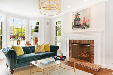 Inspiration for a mid-sized transitional living room in Chicago with white walls, medium hardwood floors, a standard fireplace, brown floor, a brick fireplace surround and no tv.