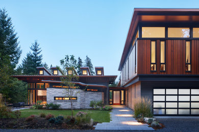 Свежая идея для дизайна: двухэтажный, деревянный частный загородный дом среднего размера в стиле модернизм с односкатной крышей, металлической крышей и отделкой доской с нащельником - отличное фото интерьера