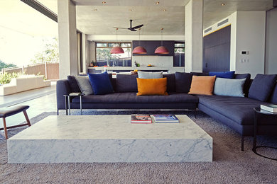 Large contemporary open concept living room in Brisbane with grey walls, concrete floors, a wall-mounted tv and grey floor.