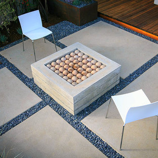 Aménagement d'un jardin à la française arrière contemporain de taille moyenne et au printemps avec une cheminée, une exposition partiellement ombragée et des pavés en béton.