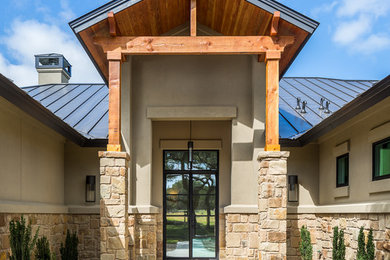 Example of a large transitional concrete floor entryway design in Austin with beige walls and a glass front door