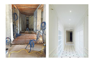 Aménagement d'un très grand couloir moderne avec un mur blanc, un sol en marbre et un sol blanc.