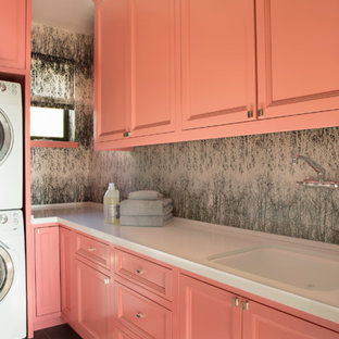Medium sized bohemian l-shaped separated utility room in Los Angeles with recessed-panel cabinets, ceramic flooring, orange cabinets, a submerged sink and grey walls.