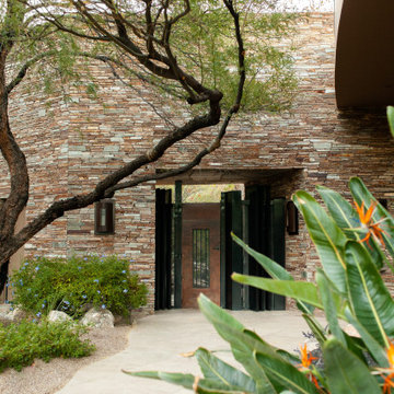 Pima CanyonThe entry walkway combines custom steel gates, stacked-stone walls, a