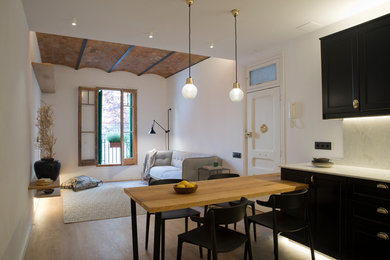 Imagen de cocina clásica renovada con armarios estilo shaker, puertas de armario negras, suelo de madera en tonos medios y península