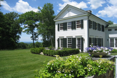 Inspiration for a large timeless white two-story vinyl exterior home remodel in New York with a metal roof