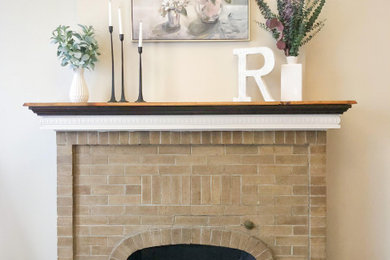 セントルイスにある低価格の小さなシャビーシック調のおしゃれなリビング (ベージュの壁、ラミネートの床、標準型暖炉、レンガの暖炉まわり、茶色い床) の写真