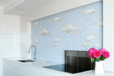 Large trendy u-shaped dark wood floor enclosed kitchen photo in Boston with an undermount sink, flat-panel cabinets, white cabinets, solid surface countertops, blue backsplash, mosaic tile backsplash, paneled appliances and an island